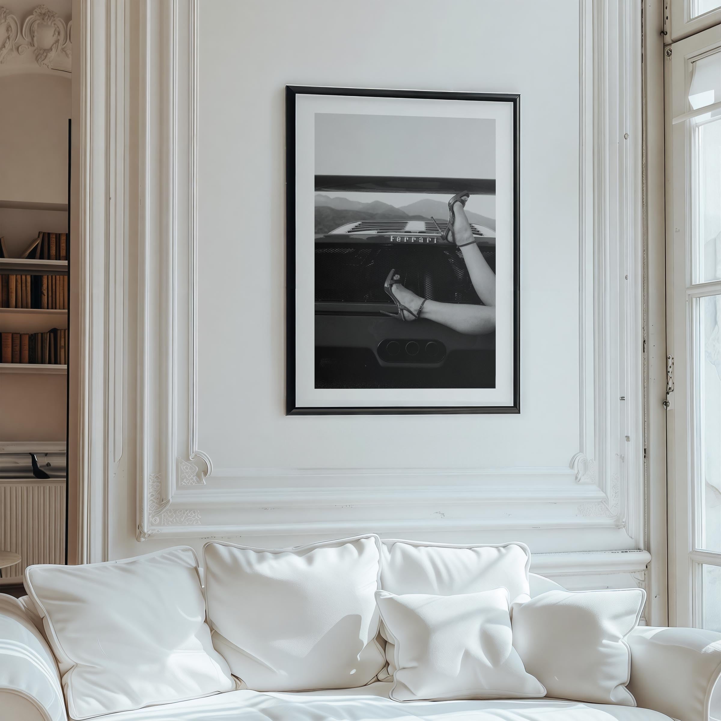 Black-and-white fine art print of high heels resting on the back of a Ferrari, framed wall art.