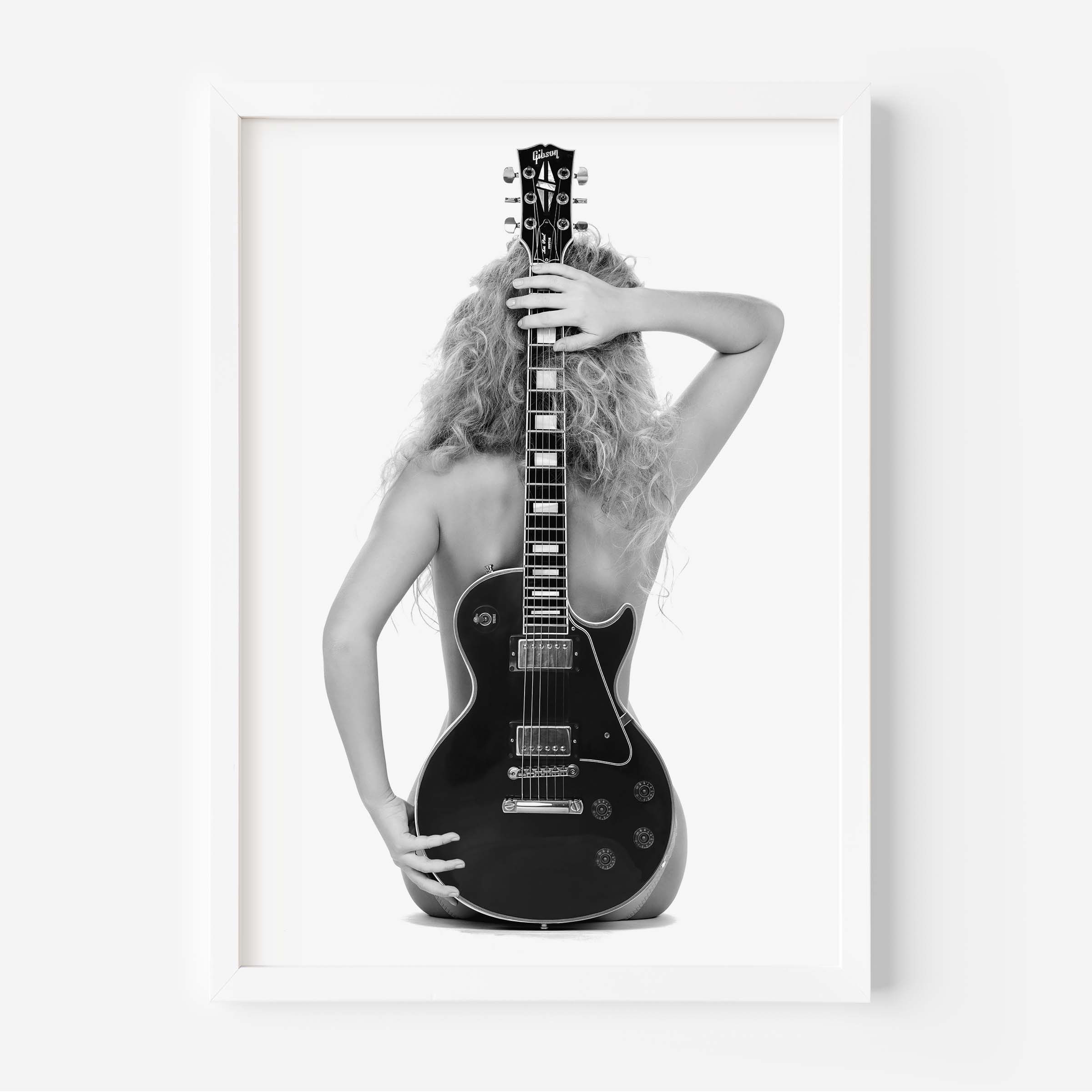 Black-and-white fine art print of a figure from behind holding an electric guitar on a white background.